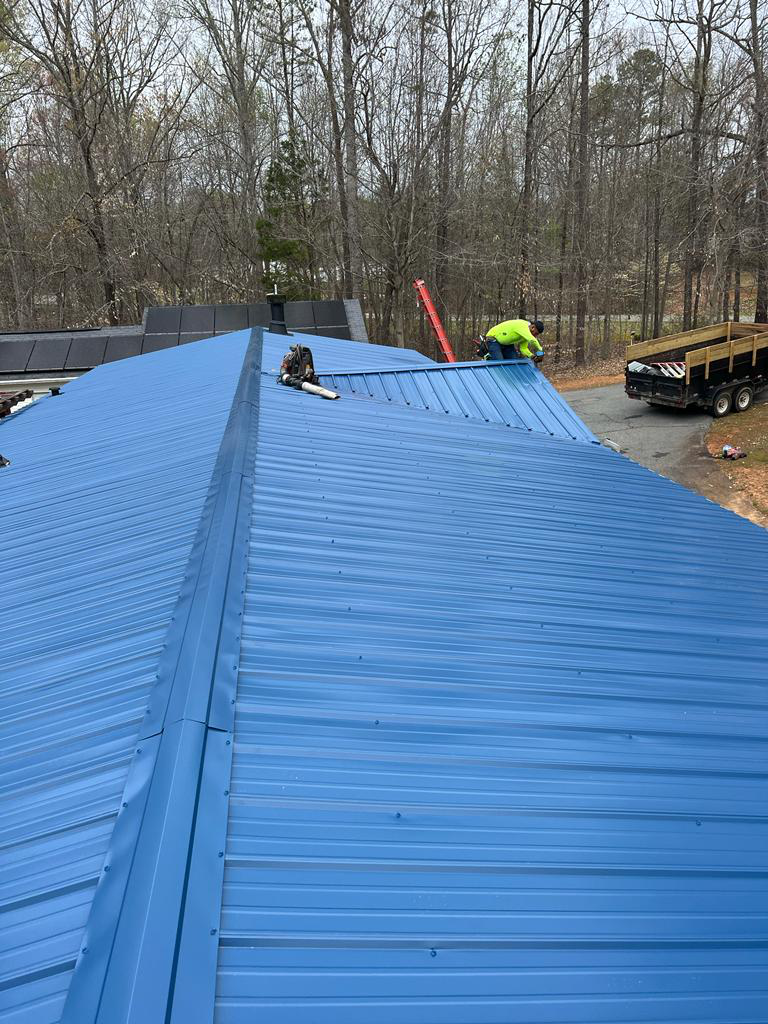 A blue metal-panelled roof is installed on a residential property.